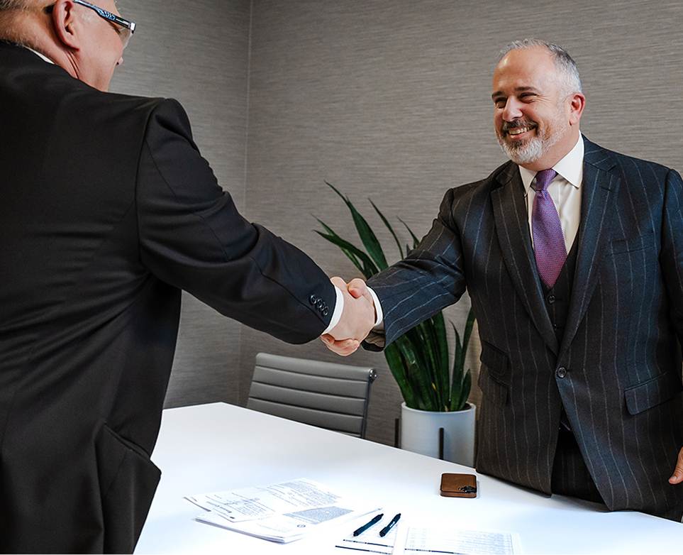 Attorney Alexander E. Sklavos, Esq. shaking hands with a client