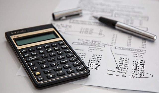 calculator, pen, and paper with numbers and markings