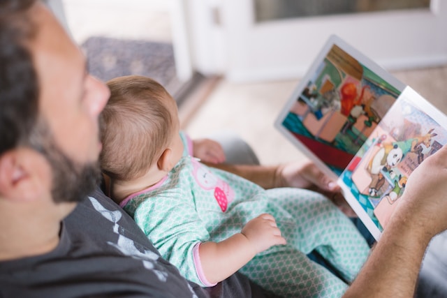 man reading book with baby