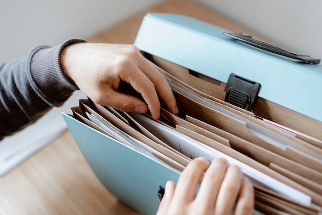 person looking through filing folder