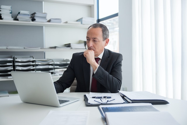 man with files looking at computer