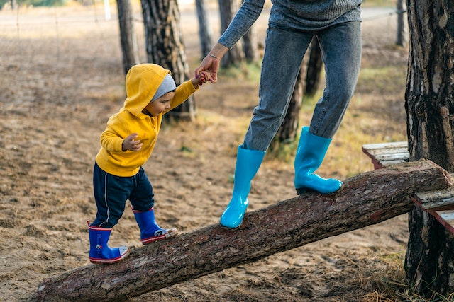dad and child walking on log